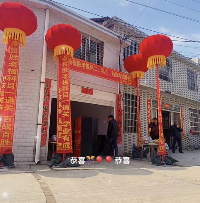 男子五年才考过科目一，朋友送条幅庆贺