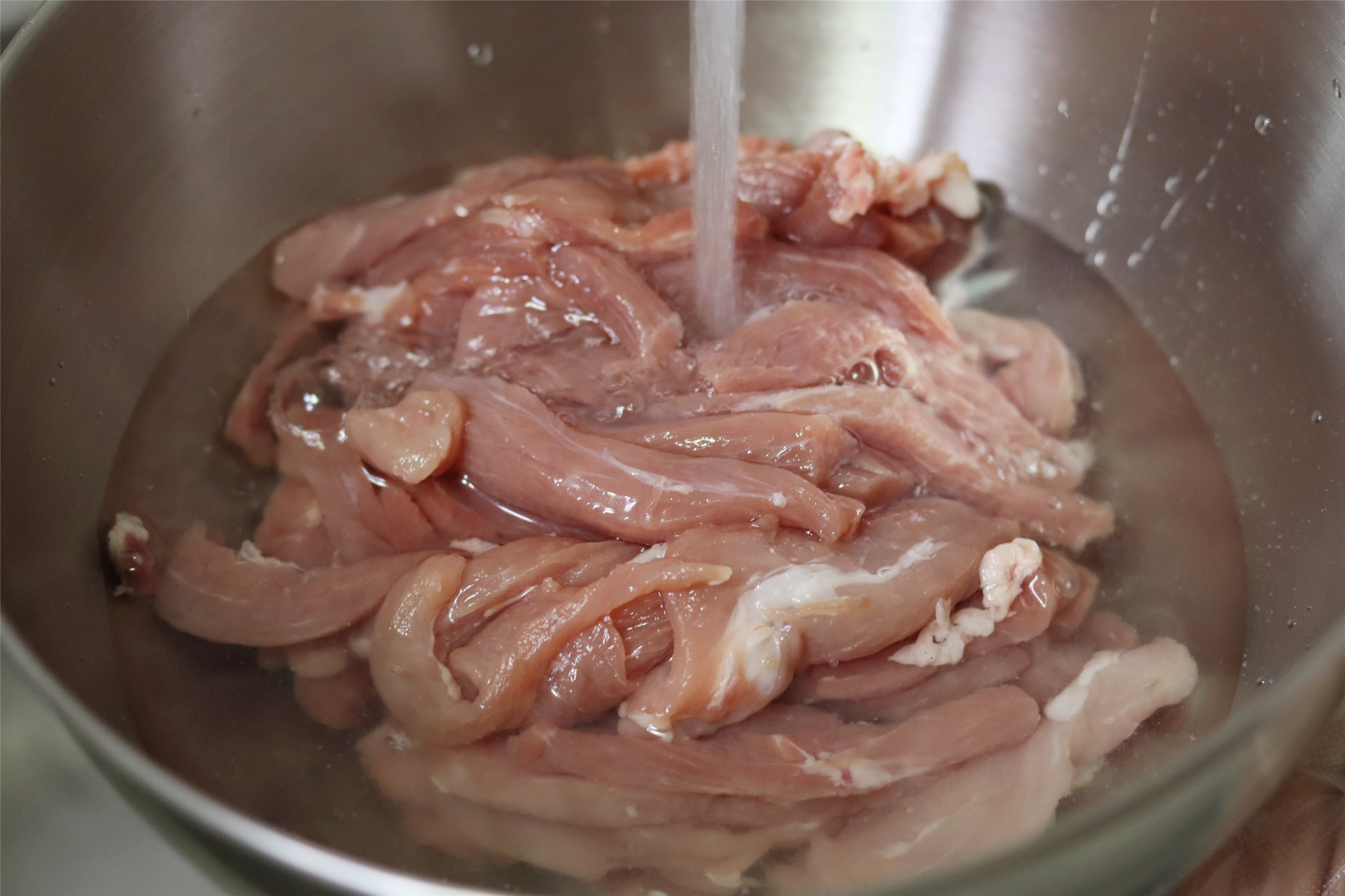 2,切好的里脊肉放入清水中重洗浸泡5分钟,析出血水,吃起来味道更纯净