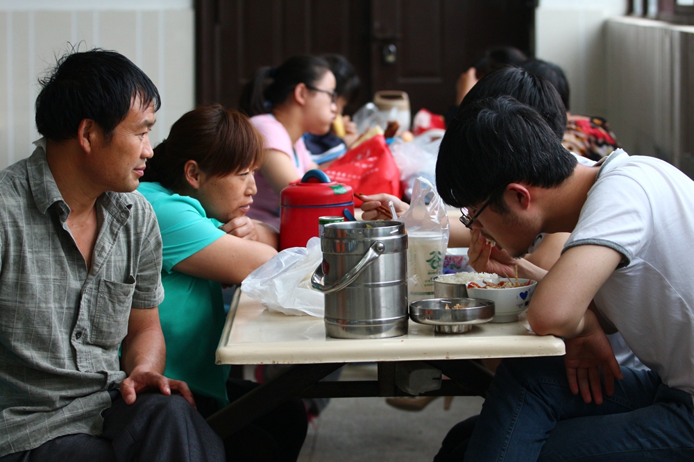 “家长送饭”成高中门口风景线，网友担心养成巨婴，家长回怼质疑