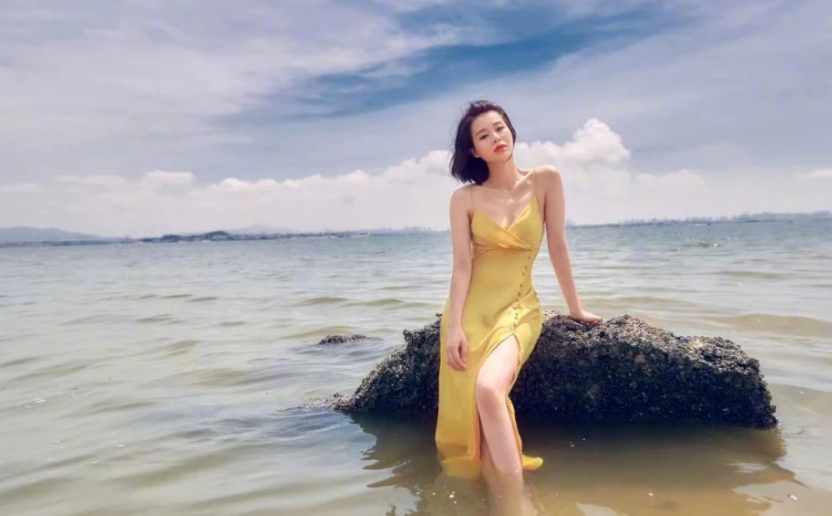 41岁胡杏儿穿吊带炫身材，光脚丫站海水中，裙子开叉秀一侧大长腿