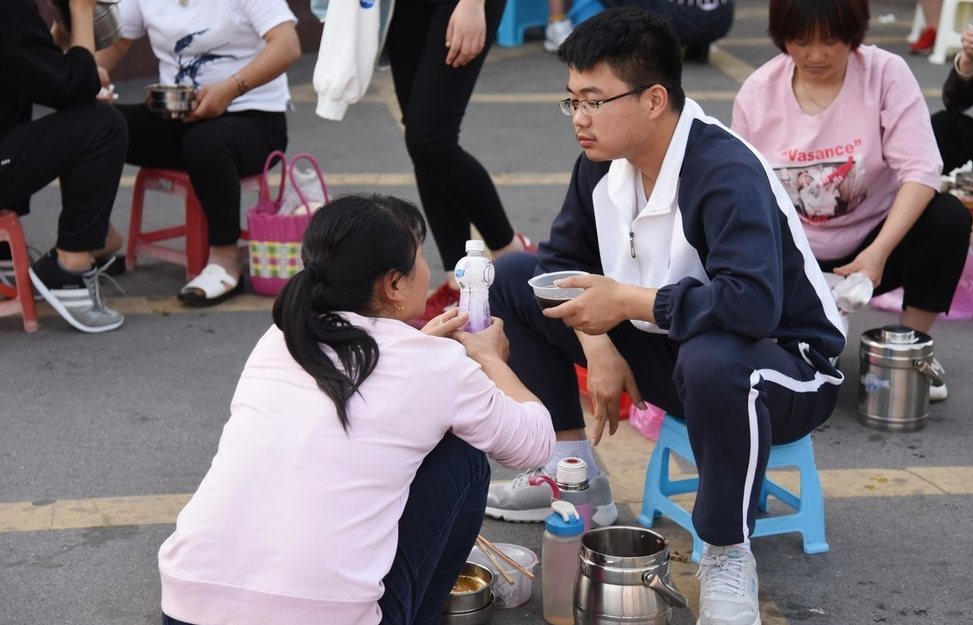 “家长送饭”成高中门口风景线，网友担心养成巨婴，家长回怼质疑