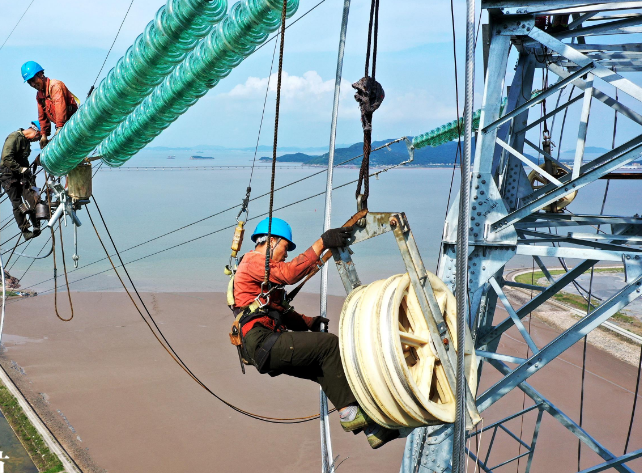 浙江舟山高空架线忙，电力施工人员佩戴成华防坠器进行安全保护