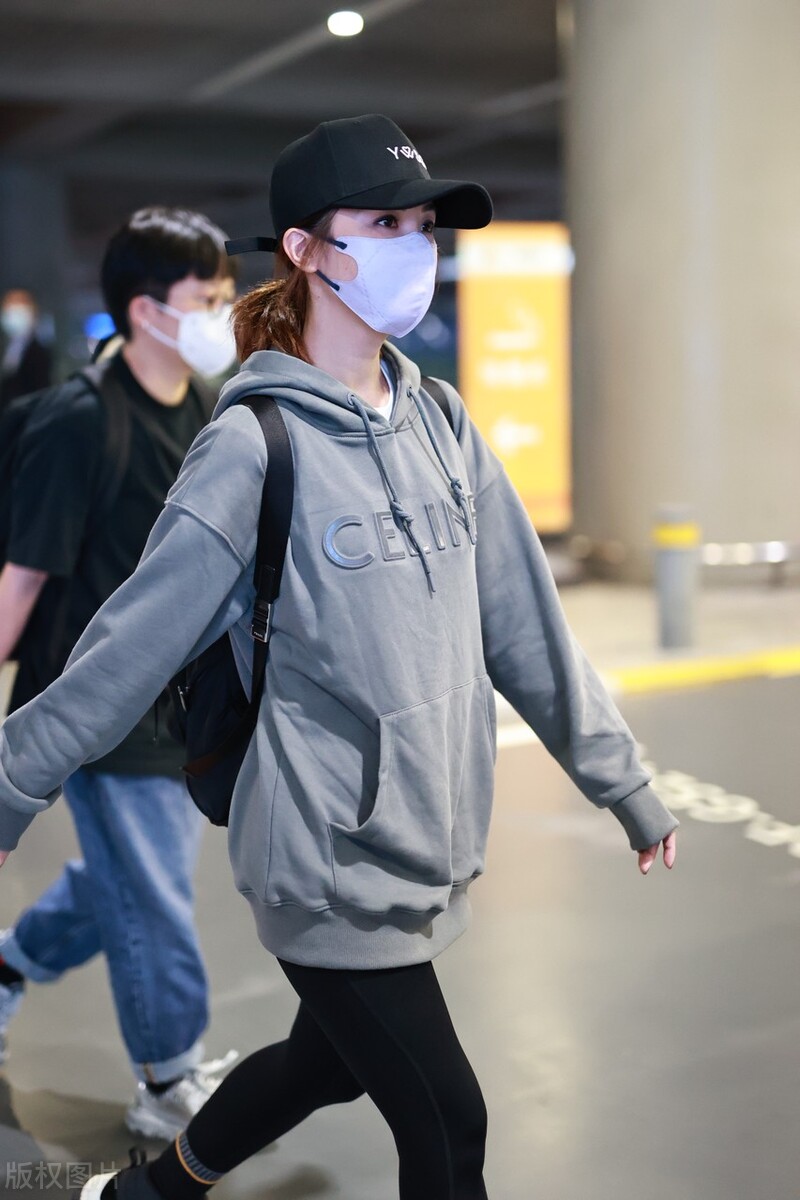 蔡卓妍穿灰色卫衣搭配黑色牛仔裤,戴棒球帽脚踩运动鞋简约随性