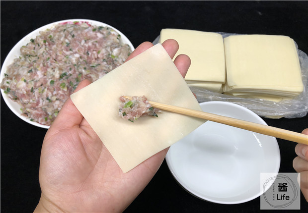 将其放到面皮的正中间,切记肉馅不要加入太多,否则抄手在熬煮的时候
