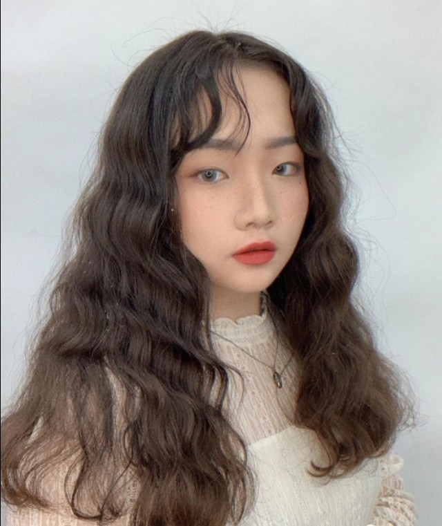 微卷的八字刘海搭配水波纹卷,清新又甜美,刘海修饰脸型显得更小巧