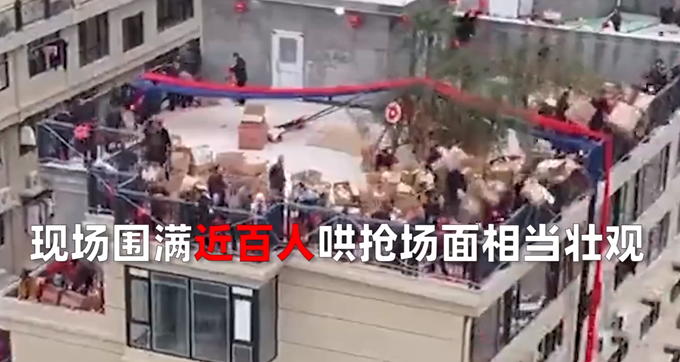 房主庆祝乔迁顶楼倾倒几十箱礼物，近百人围观沾喜气，场面壮观
