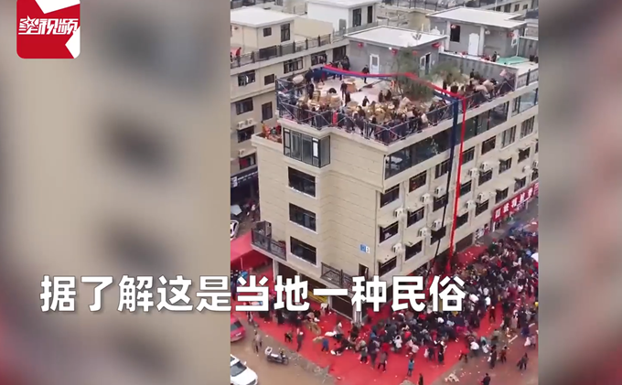 房主庆祝乔迁顶楼倾倒几十箱礼物，近百人围观沾喜气，场面壮观