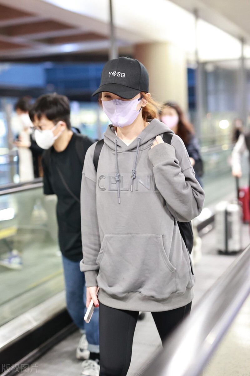 蔡卓妍穿灰色卫衣搭配黑色牛仔裤,戴棒球帽脚踩运动鞋简约随性