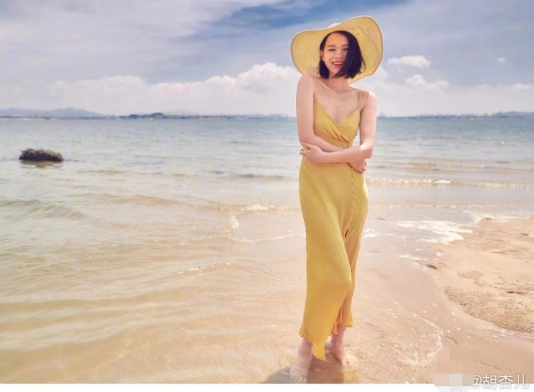 41岁胡杏儿穿吊带炫身材，光脚丫站海水中，裙子开叉秀一侧大长腿