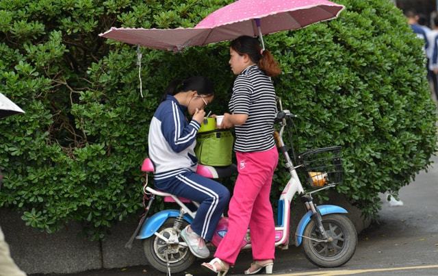 “家长送饭”成高中门口风景线，网友担心养成巨婴，家长回怼质疑