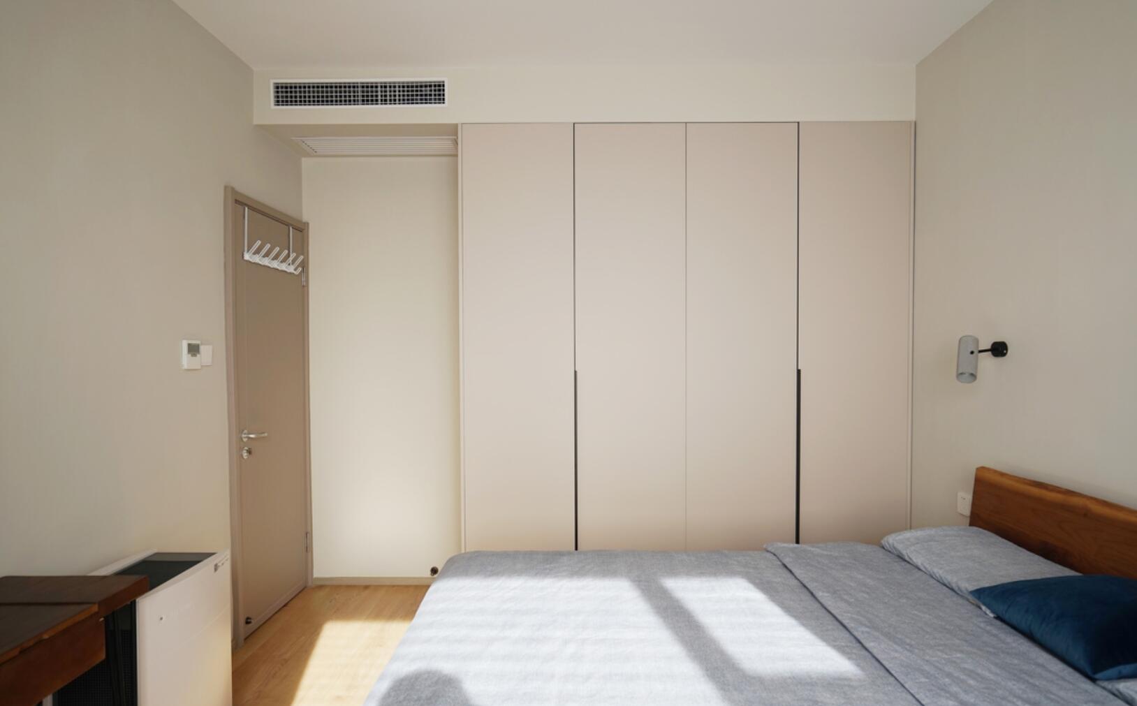 主卧设计同样很简洁,墙面刷上低饱和度的杏色乳胶漆,立马就为空间带来