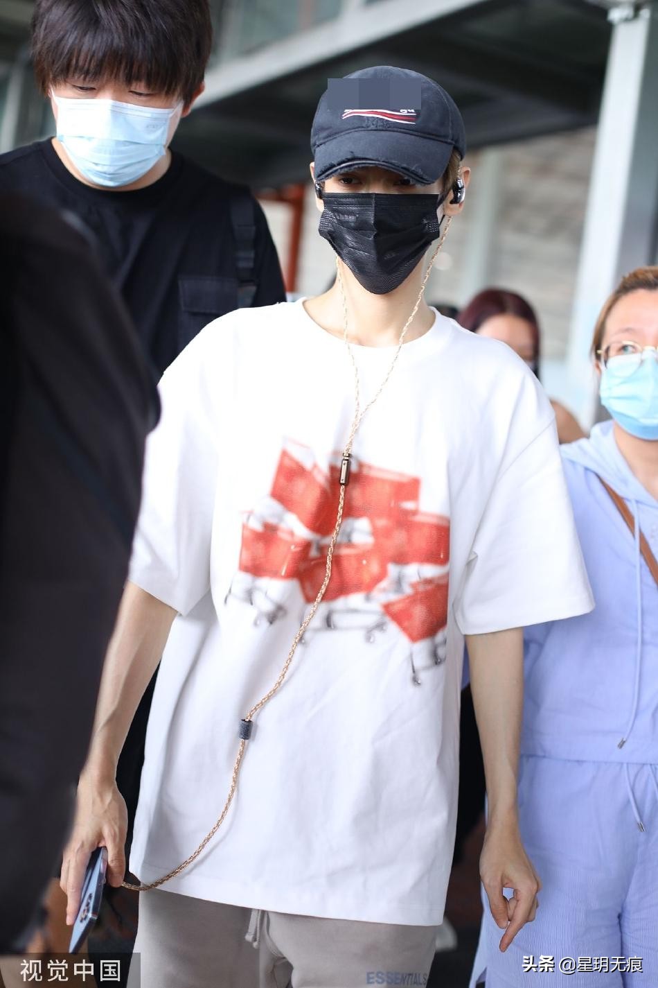 罗云熙机场一路看手机前行 穿白色T恤搭大短裤清爽干净