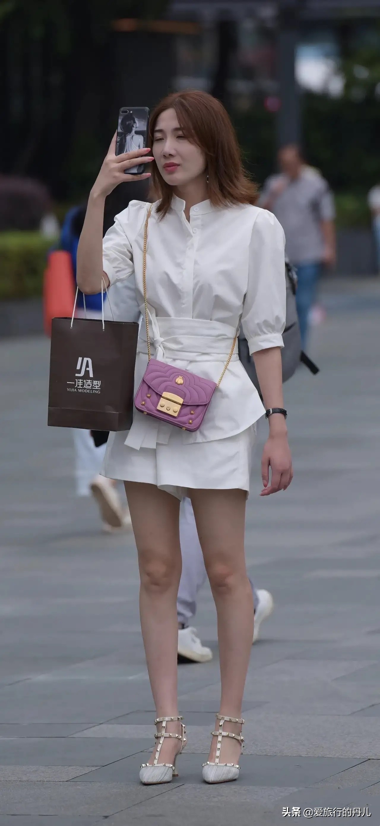 小姐姐身穿白色长款衬衫搭配白色休闲短裤，清新又时尚