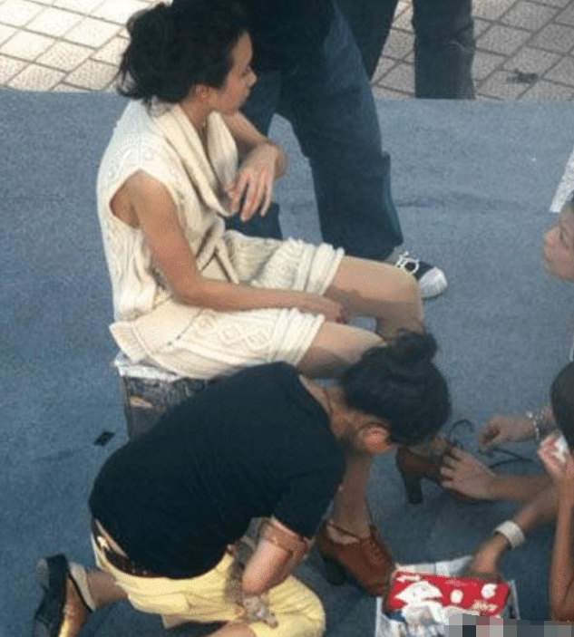 李小璐现身酒吧被批，穿着清凉露出大白腿，俩助理蹲地上为其穿鞋