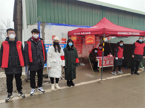 駐馬店市驛城區水屯鎮新李莊村防控檢測點大學生志願者雪雨抗疫情