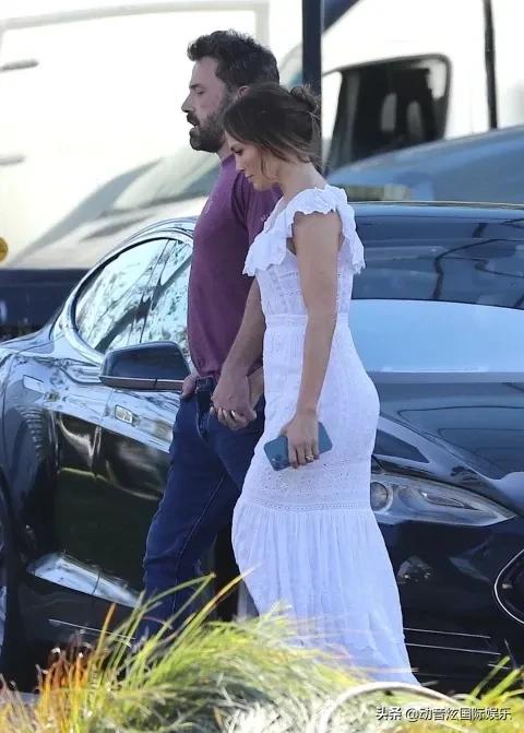 詹妮弗洛佩兹身着飘逸的白色礼服与未婚夫手牵手走在片场上