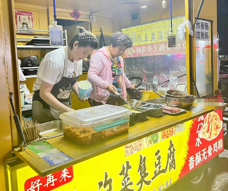 44岁谭晶回山西老家，在路边摊旁蹲坐吃臭豆腐，不戴口罩无人识