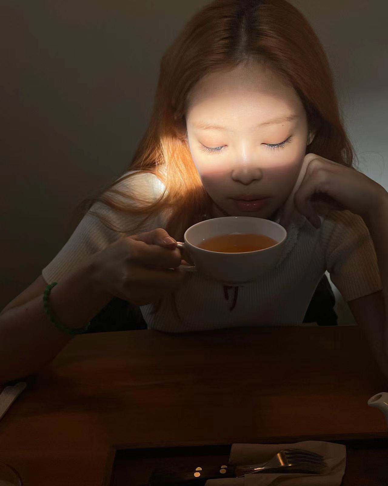 红润的腮红，Jennie悠闲品茶，幽暗中晒下一缕阳光，氛围很是优雅
