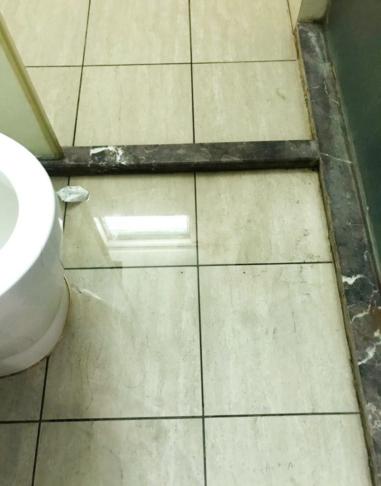 卫生间地面出现不明积水，疑似管道漏水或防水层破损导致。