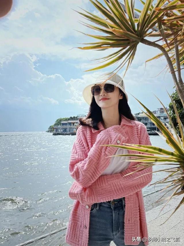 景甜置身碧海蓝天 穿粉外套撩拨长发好甜美