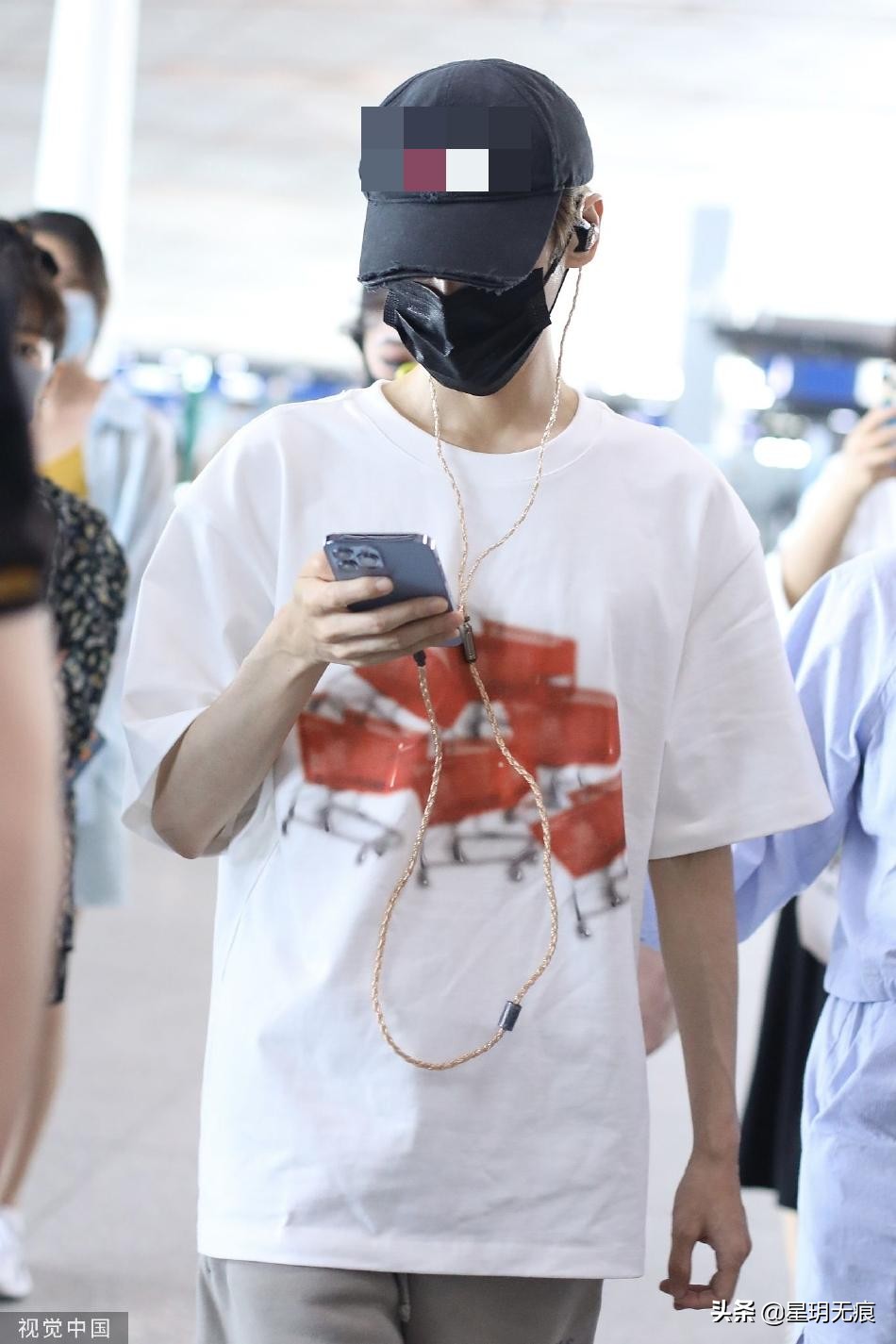 罗云熙机场一路看手机前行 穿白色T恤搭大短裤清爽干净