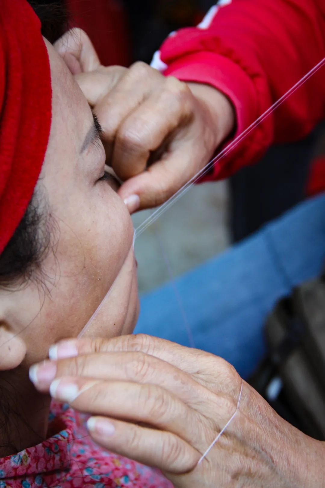 绞面师阿姐手法娴熟,咬着线的口与左手配合,右手两指一开一合,滚动的